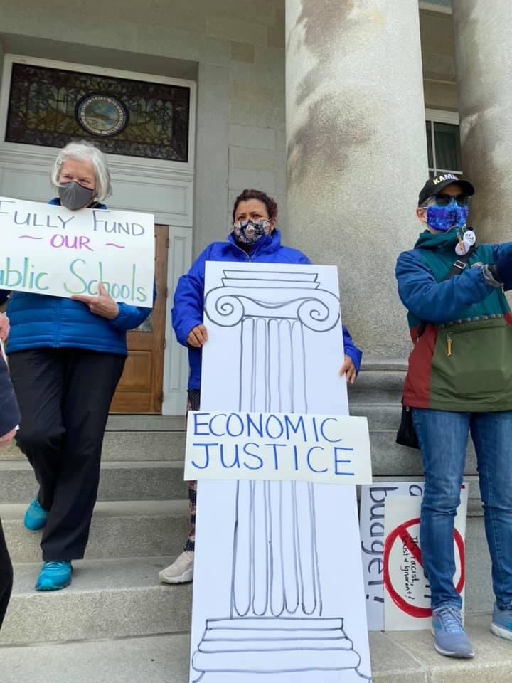 State Rep. Maria Perez holds Economic Justice Pillar sign